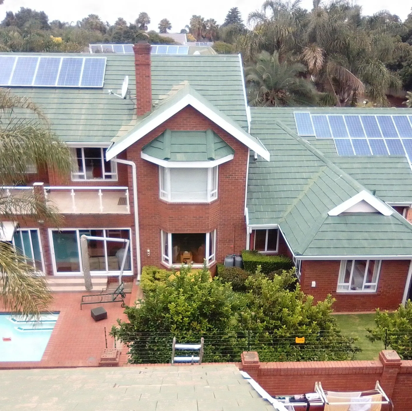 Full seamless gutter and downpipe run on a double-storey face-brick home