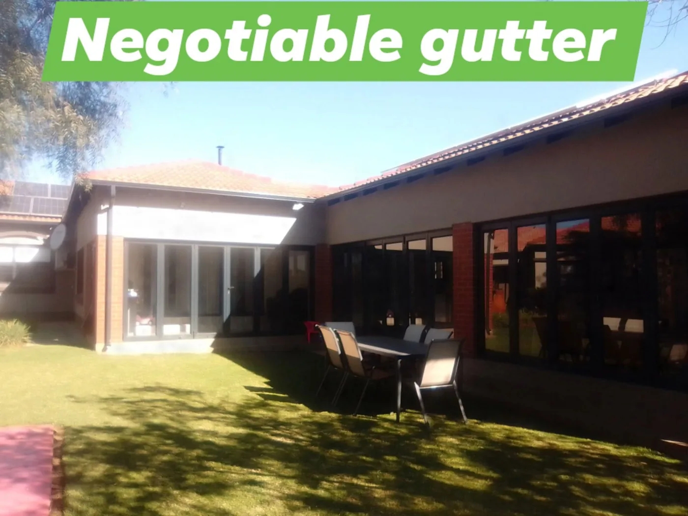 Charcoal seamless gutters wrapping a single-storey home and patio